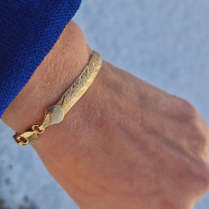 Armband tillverkad i äkta guld. Stelt med fint glittrande mönster. I väldigt bra skick.